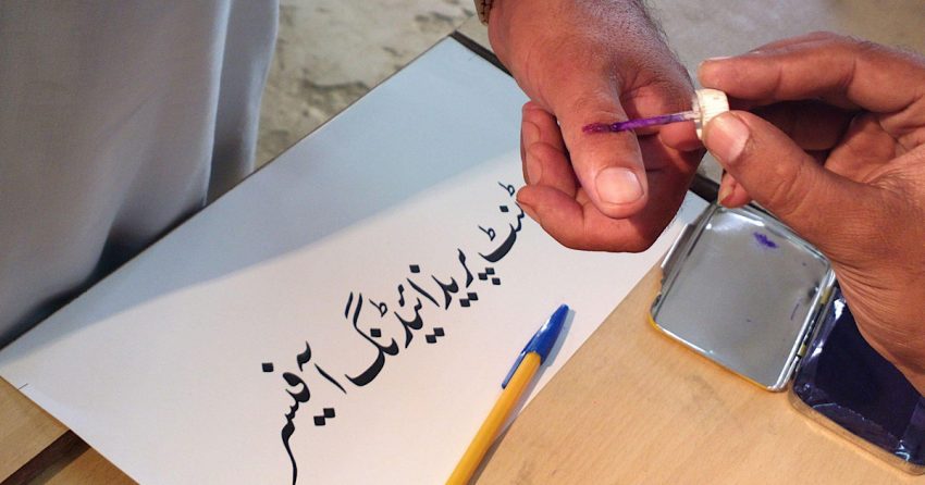 A man is preparing to cast his vote on the day of general election in Pakistan.